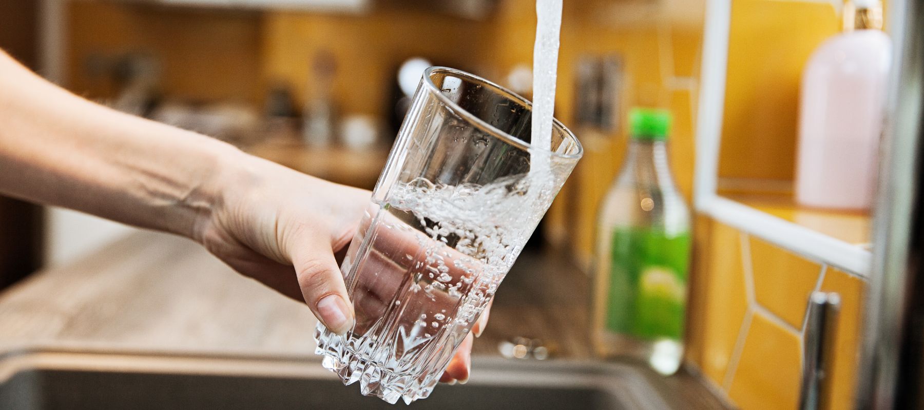 someone filling up a glass of water